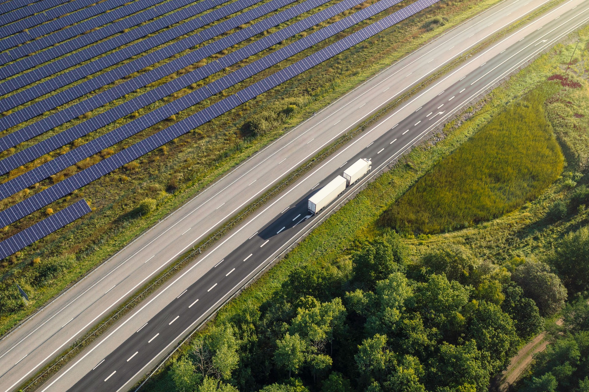 Truck on the road through a landscape with solar panels